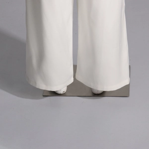 Détail d'un pantalon blanc à jambes larges avec un tombé fluide et un ourlet net