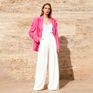 Detail of rose pink blazer featuring 3D floral embellishments on sleeves and lapels