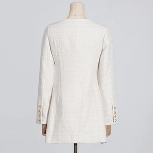 Detail view of the tweed dress back showing woven texture and decorative cuff buttons