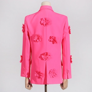 Detail view of 3D fabric flower appliqués on the back of a magenta pink blazer