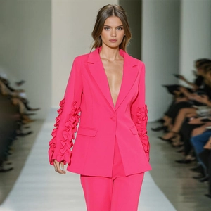 Detail eines fuchsiafarbenen Blazers mit Rüschenärmeln und passender Schlaghose auf dem Laufsteg