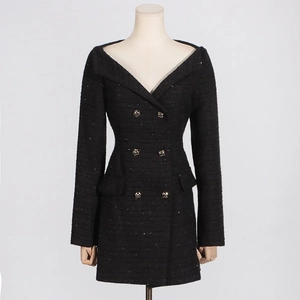 Close-up of black tweed off-shoulder dress featuring metallic buttons and sequin texture