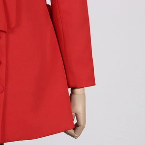 Détail de blazer rouge montrant la coupe ajustée et les boutons recouverts de tissu assorti