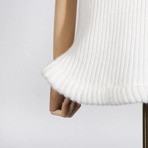 Detailed macro view of the soft white rib-knit texture and hem on a women's sweater