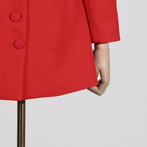 Détail d'un blazer rouge montrant le tissu de qualité et les boutons recouverts