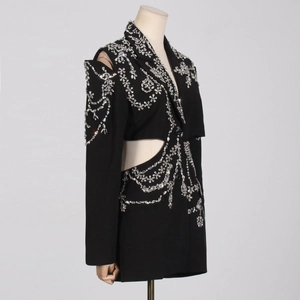 Detail of floral rhinestone embellishments and fringe on a black luxury blazer dress