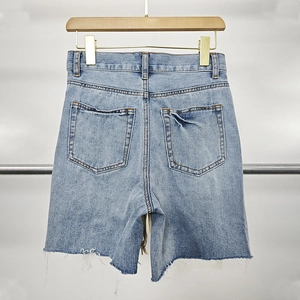 Detail view of denim shorts with high waist cut, back pockets and frayed hem design