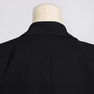 Detailed close-up of the black wool-blend blazer collar and shoulder seam stitching