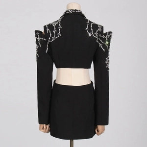 Detail of the back view showing rhinestone floral patterns on a black luxury blazer