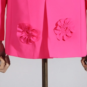 Detail of rose pink blazer hem featuring symmetrical 3D pleated fabric flower ornaments