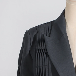 Detail of elegant pleated shoulder design on a premium black tailored women blazer jacket