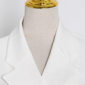 Detail view of the elegant white blazer lapel showing fine twill fabric texture