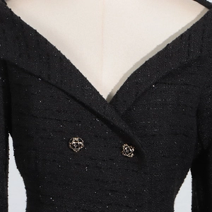 Detail of black tweed dress texture with sparkling sequins and gold buttons