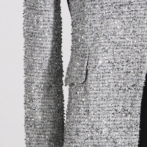 Macro shot of silver sequined tweed fabric texture with slim fit sleeve and pocket detail