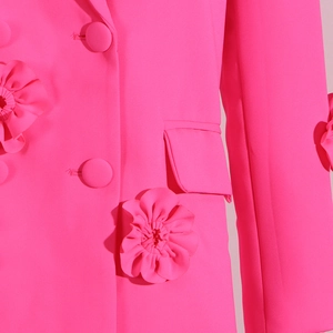 Detailed view of 3D fabric flower appliqués on the bright pink tailored women blazer
