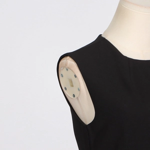 Détail d'un haut noir sans manches avec col rond et tissu texturé de haute qualité