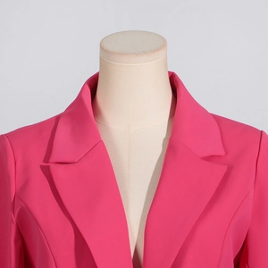 Detailaufnahme des klassischen Revers und der Schulternaht an einem pinkfarbenen Blazer