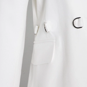 Detail of white blazer showing high-quality woven fabric and metal D-ring buckle trim