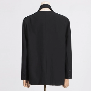 Détail arrière d'un blazer noir avec boutons aux poignets et couture centrale au dos