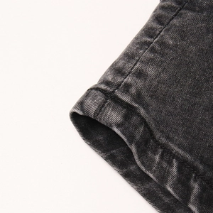 Gros plan sur les doubles coutures et la texture denim lavé du short-jupe noir fashion
