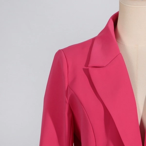 Detailansicht der leuchtend rosaroten Blazer-Stoffstruktur und des klassischen Revers