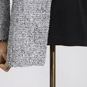 Detailed close-up of contrast silver sequin fabric and black plain fabric on a blazer
