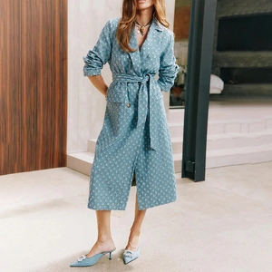 Détail du long manteau bleu clair texturé avec revers crantés et ceinture assortie