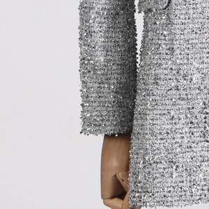 Detail of silver tweed fabric with shimmering sequins on a professional wooden mannequin