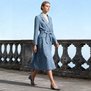 Détail d'un trench-coat en jacquard bleu clair avec col à revers et ceinture assortie