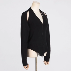Detail of black ribbed knit top featuring a metal zipper and creative cutout design