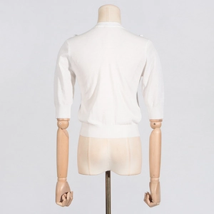 Rear view of white short-sleeve knit top with ribbed cuffs and hem on a mannequin