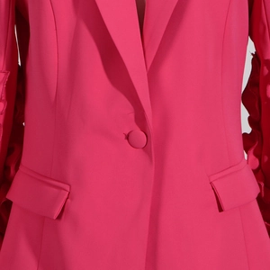 Detail eines rosaroten Blazers mit Reverskragen und eleganten Rüschenbündchen Design