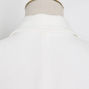 Close-up of elegant white blazer lapel showing premium twill fabric texture and stitching