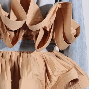 Detail view of denim and khaki ruffles on a stylish long-sleeve patchwork jacket