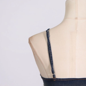 Detail of adjustable thin straps with metal buckles on a dark blue denim top for women
