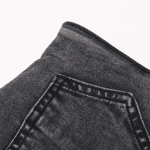 Gros plan du short en jean délavé vintage montrant la poche arrière et les doubles coutures