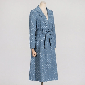Vue détaillée d'un trench-coat à paillettes bleu clair avec ceinture sur un mannequin
