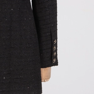 Detail of tweed dress sleeve with four textured metal buttons and subtle glitter fibers