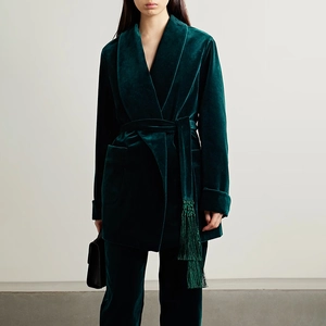 Detailed view of dark green velvet blazer with waist tie and delicate tassel trim