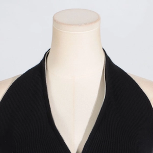 Close-up of black ribbed knit halter top featuring elegant silver metal chain trim