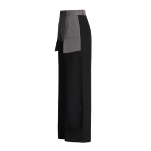 Detail view of high-waist wide-leg trousers featuring a unique black and grey patchwork design