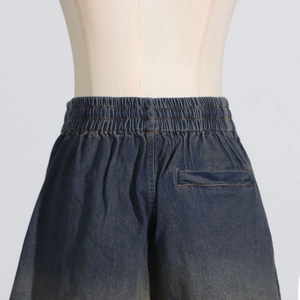 Detail of dark blue denim shorts with elastic waistband and back pocket on mannequin