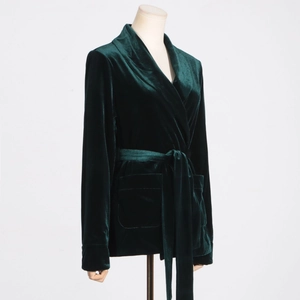 Detail of dark green velvet blazer with shawl collar, waist tie and large pockets