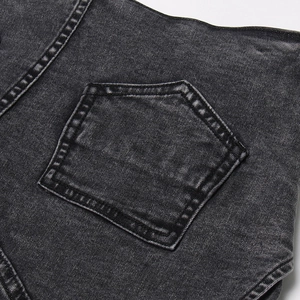 Détail d'une poche pentagonale sur un short en jean délavé avec double couture