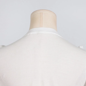 Detail of white knit top showing ribbed neckline and fine stitching on the shoulder area