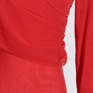 Detail of red mesh top featuring elegant ruched pleats and textured lightweight fabric