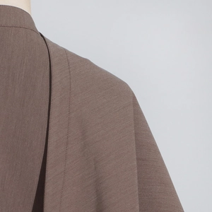 Detailed close-up of stitching on mocha brown blazer shoulder and neck collar