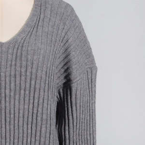 Detail of gray V-neck knitted sweater with vertical ribbed texture and drop shoulders