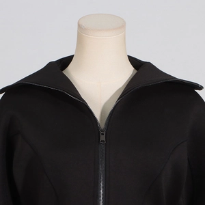 Detail view of smooth black stand collar jacket with high-quality metal zipper