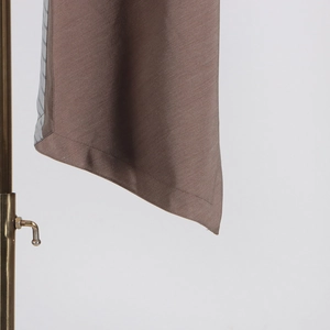 Macro detail of tan fabric texture and precision stitching on a women's blazer